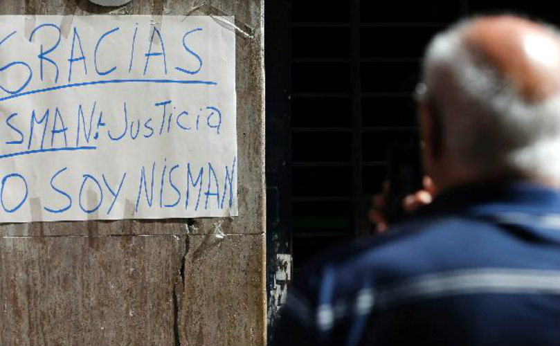 Un hombre mira uno de los carteles en apoyo al fiscal fallecido.